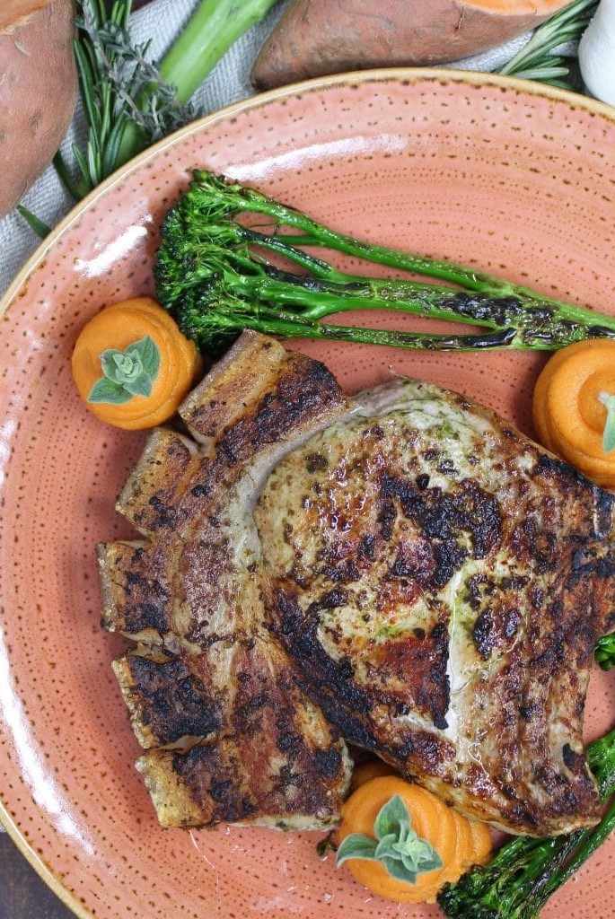 Carré con hueso al pesto con brócoli y puré de batatas